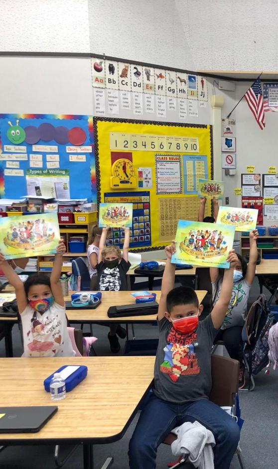 First graders wearing masks holding a book.